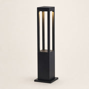 Black rectangular outdoor bollard light with warm vertical illumination on a plain light background.