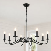 Black six-light candle chandelier with glowing bulbs hanging from a chain in a bright room.