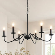 Black six-light chandelier with candle-style bulbs hanging above a bright room.