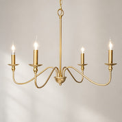 Gold five-light chandelier with curved arms and candle-style bulbs on a pale gray background.