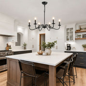 Black six-light chandelier hanging above a white kitchen island