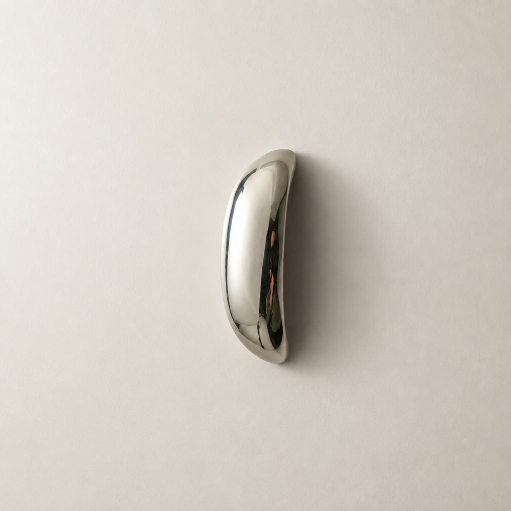 Polished chrome curved handle on a plain light surface.