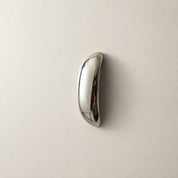 Polished chrome curved handle on a plain light surface.