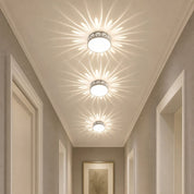 Three decorative ceiling lights cast floral patterns along a hallway ceiling.