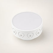 White round bowl with gray heart and dot cutout pattern around the sides.
