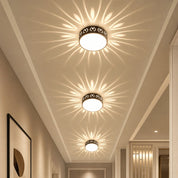 Three decorative flush mount ceiling lights cast floral light patterns along a hallway.