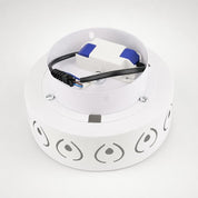 White circular LED light fixture with visible driver and wiring on top.
