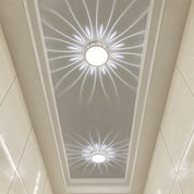 Two round ceiling lights cast floral white patterns across a recessed glossy ceiling.