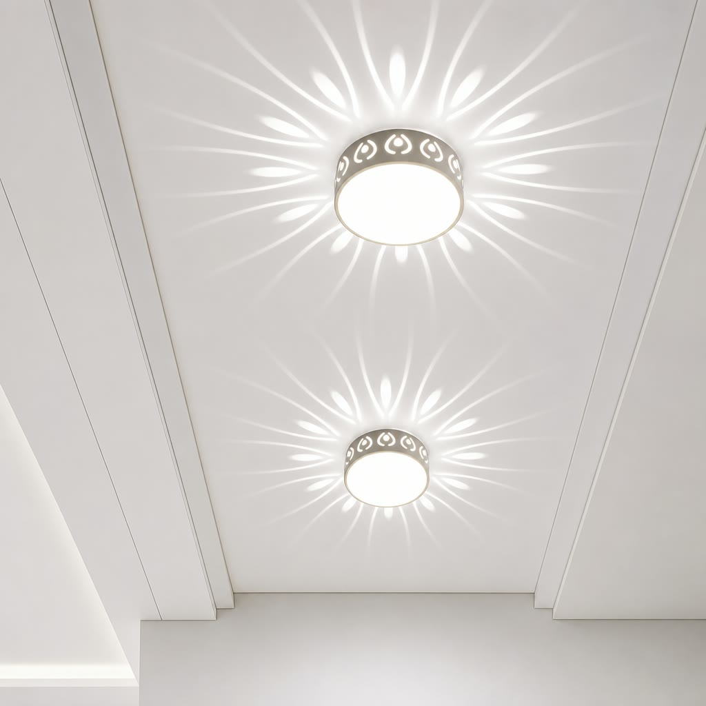 Two round flush ceiling lights with patterned rims casting floral rays on a white ceiling.