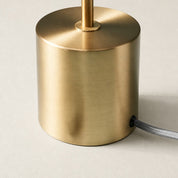 Brushed brass cylindrical lamp base with a vertical stem and gray braided cord.