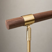 Brass and wood rail support with a cylindrical wooden bar and gold mounting bracket.