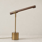 Brass and wood desk lamp with a slim angled bar shade on a round base.