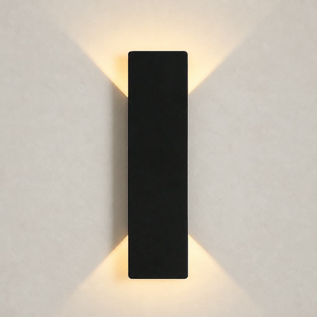 Black rectangular wall sconce casting warm light upward and downward on a plain wall.