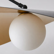 White spherical pendant light beneath a curved beige shade with a black mounting rod.