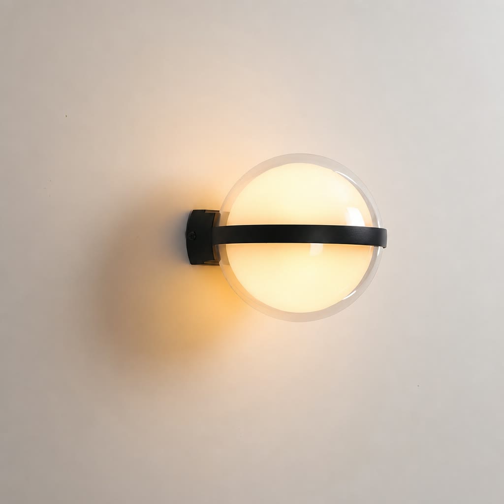 Black wall sconce with a glowing round frosted globe on a pale wall.