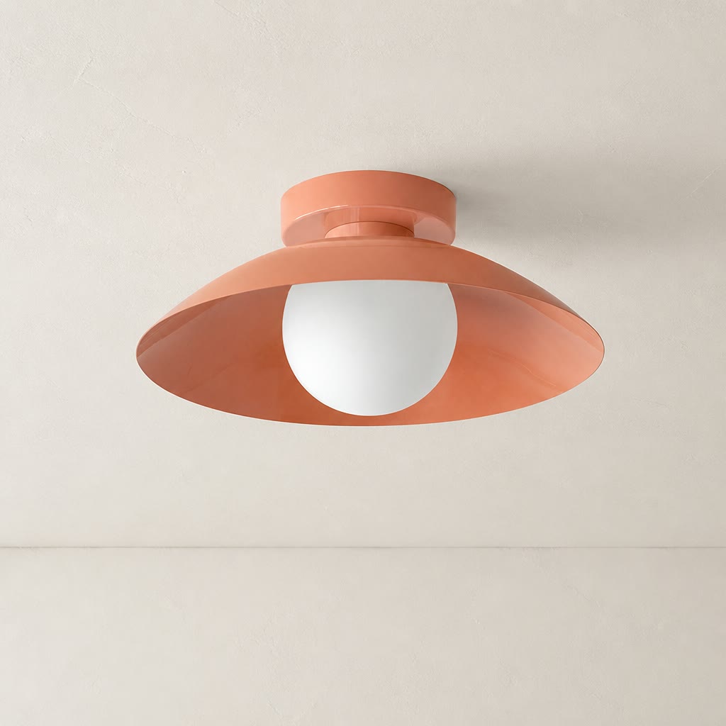 Coral ceiling light with wide saucer shade and white globe bulb on a pale ceiling.