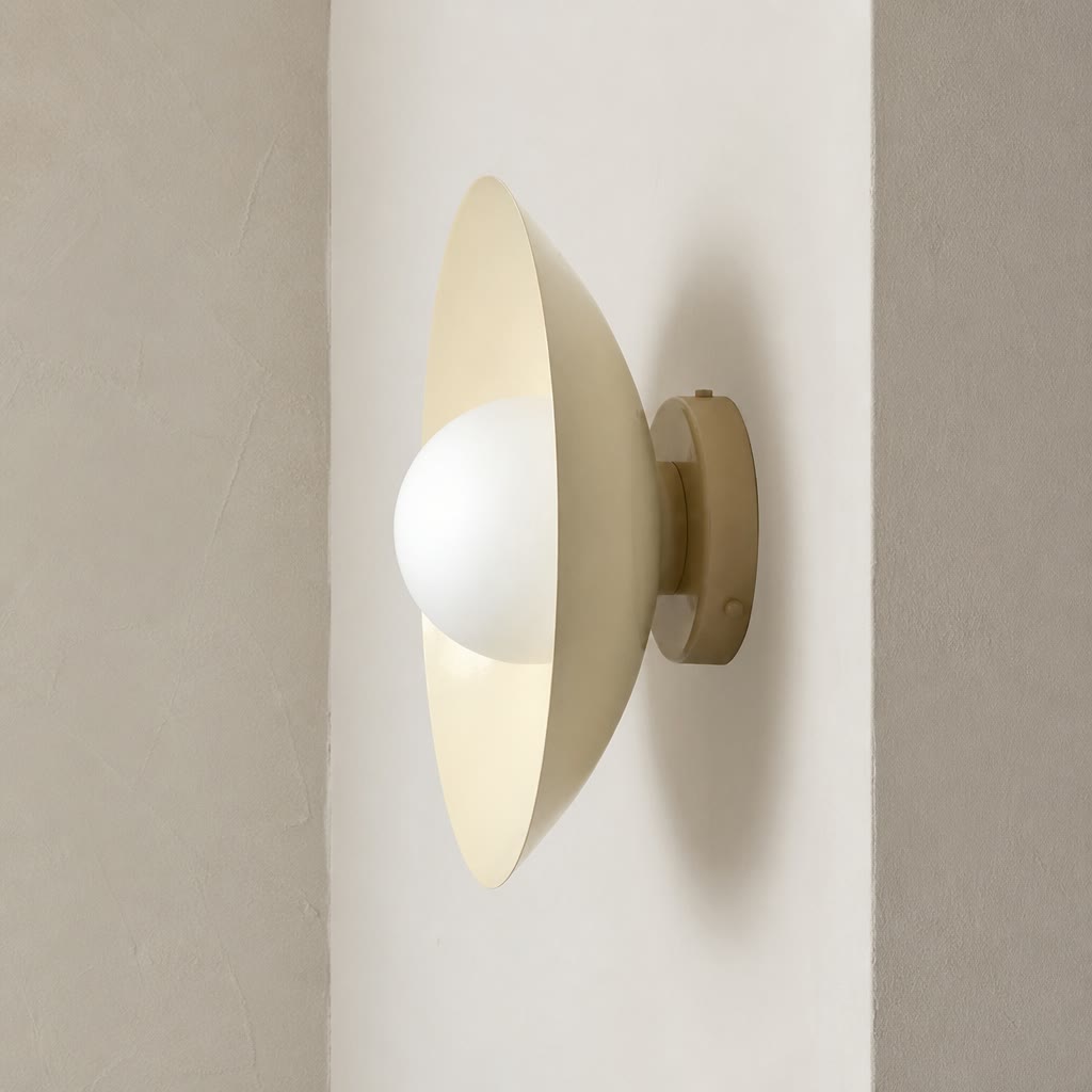 Cream wall sconce with a white globe bulb mounted on a neutral wall.