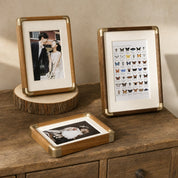 Wooden photo frames with brass corners displayed on a rustic tabletop.