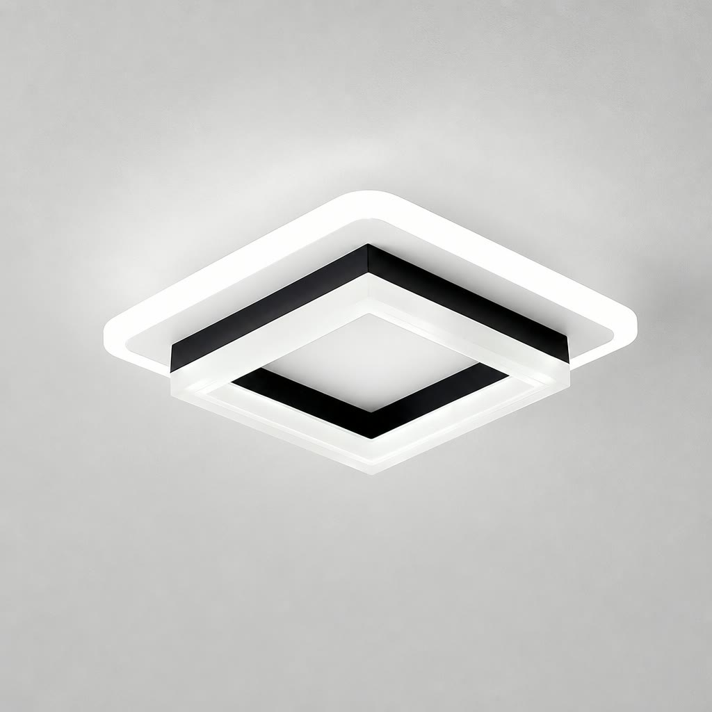 Square black and white ceiling light with a glowing white rim on a plain gray ceiling.