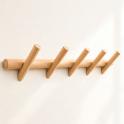 Light wood wall rack with five angled round pegs on a clean white background.