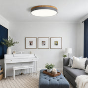 Round wood-and-charcoal flush mount ceiling light in a bright living room.