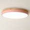 Round flush mount ceiling light with a pink side band and wood-tone rim.