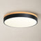Round ceiling light with wood trim, black band, and glowing white diffuser.
