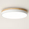 Round ceiling light with wood trim, white metal band, and glowing white diffuser.