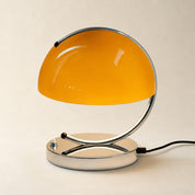 Orange dome table lamp with chrome curved arm, oval base, and black power cord.