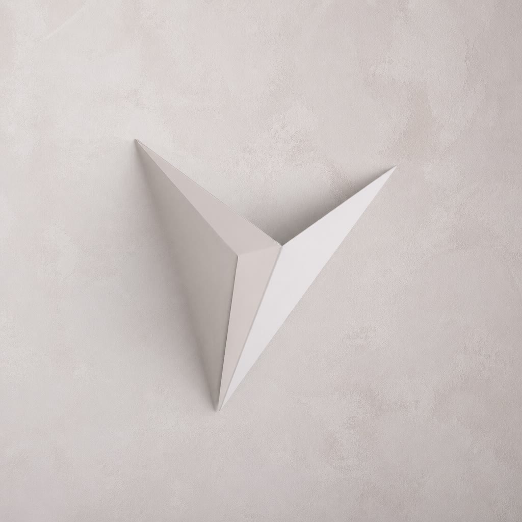 A minimalist, white, v-shaped Starry Night wall sconce against a textured, light-colored wall.