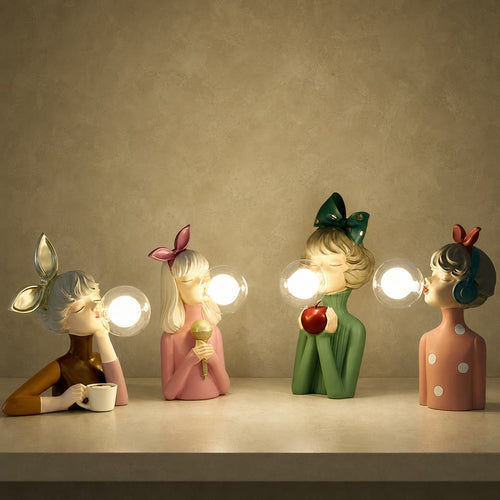 Four decorative girl figurine lamps with glowing bubble lights and colorful bows on a shelf.