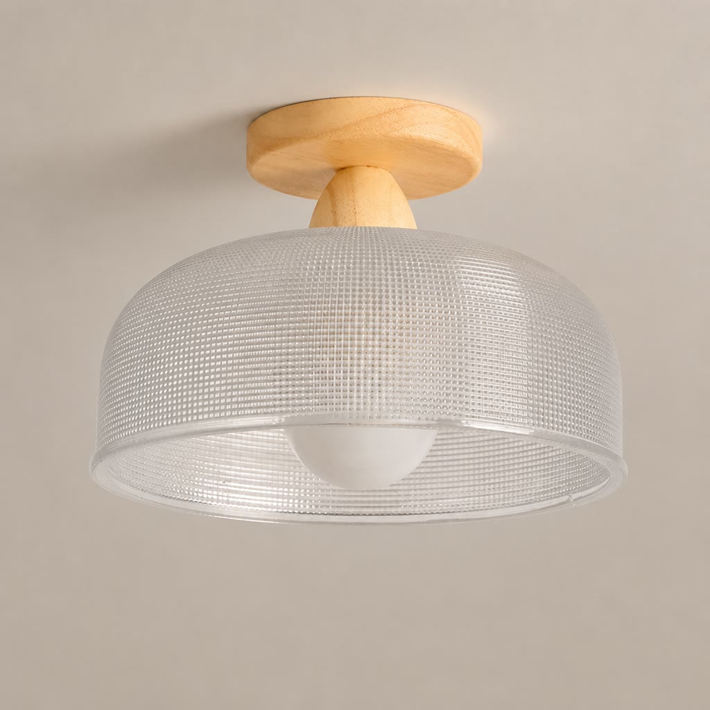 Flush mount ceiling light with wood base and translucent textured drum shade.