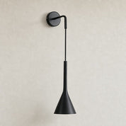 Black wall-mounted sconce with round backplate and tapered cone shade on a light wall.