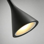 Black cone pendant lamp with a warm glowing underside on a gray background.