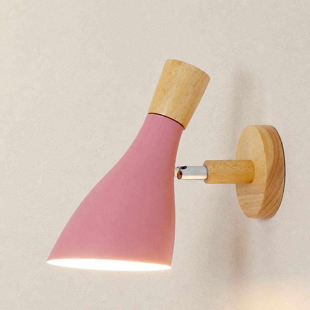Pink cone wall sconce with wooden accents lit against a pale textured wall.