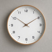 Round wall clock with wood rim, white face, black numerals, and brown hands.