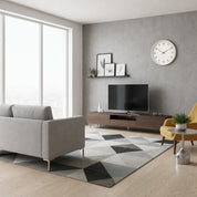 Modern living room with gray sofa, TV console, yellow chair, patterned rug, and wall clock.