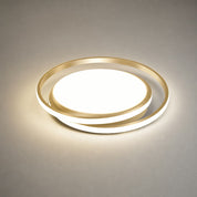Gold circular LED ceiling light glowing on a neutral surface.