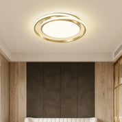 Gold circular ceiling light glowing above a modern room with wood and dark wall panels.