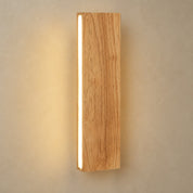 Wooden wall sconce with a vertical warm LED strip on a neutral wall.