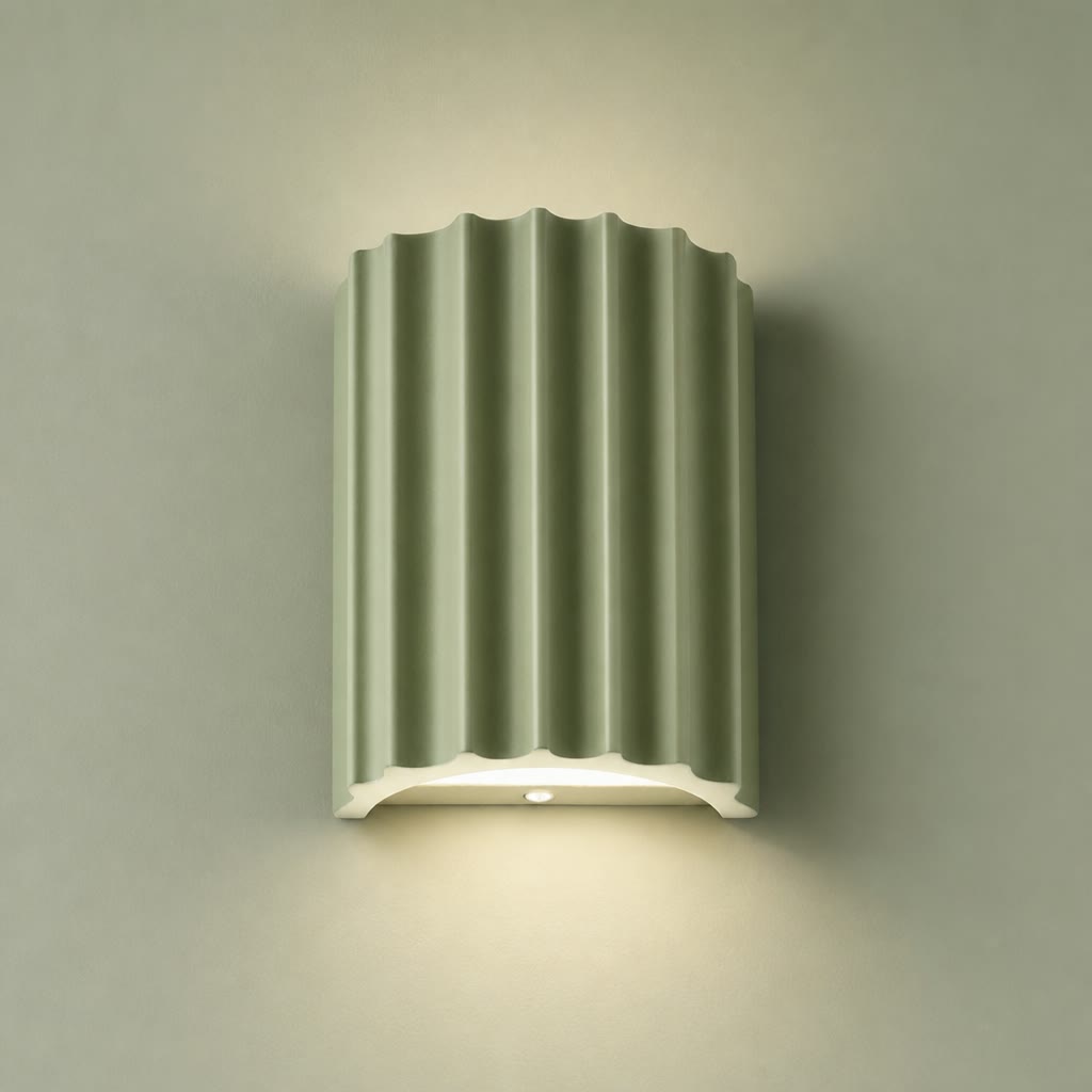 Sage green fluted wall lamp with a white base casting a soft downward glow.
