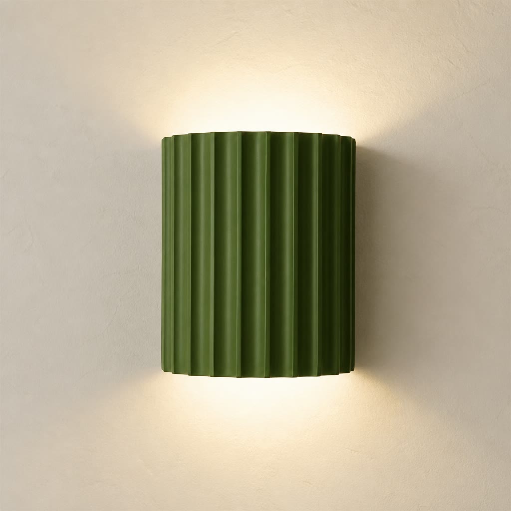 Olive green ribbed wall sconce glowing softly on a plain light wall.