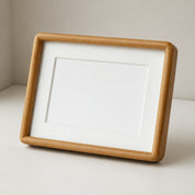 Wooden tabletop photo frame with a white mat and blank inner opening.
