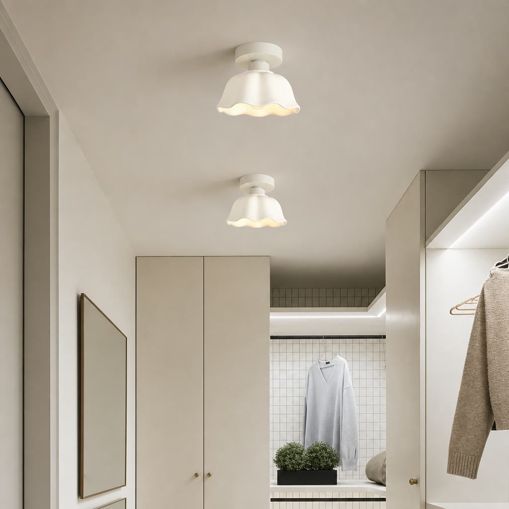 Two white wavy-edged ceiling lights in a minimalist wardrobe hallway.