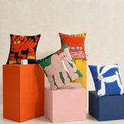 Animal-themed throw pillows arranged on colorful display blocks.