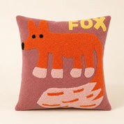 Pink square fox pillow with orange fox design and yellow FOX lettering.