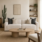 Cream sofa with neutral throw pillows in a warm minimalist living room.