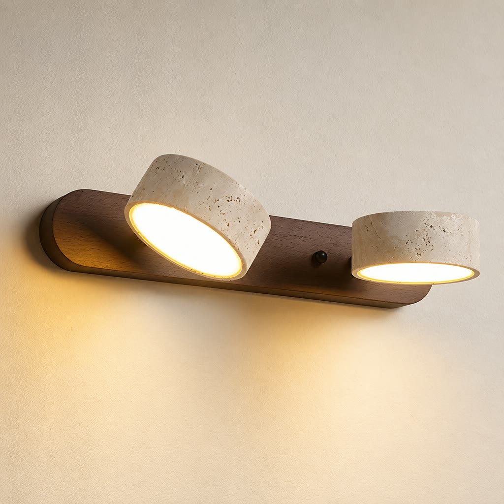 Two-light wall sconce with wood backplate and cream stone shades glowing warmly.