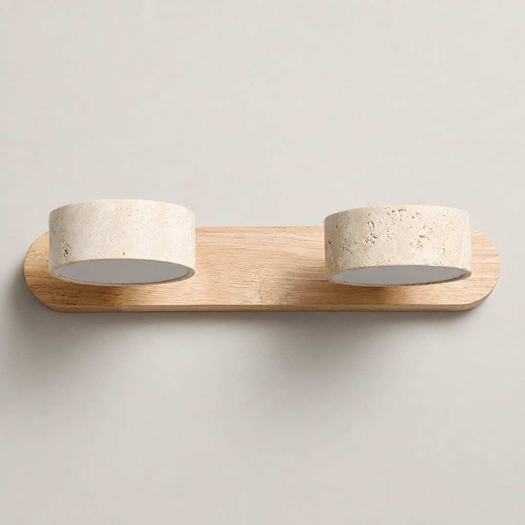 Double cylindrical stone wall light on a rounded wooden base against a plain neutral wall.