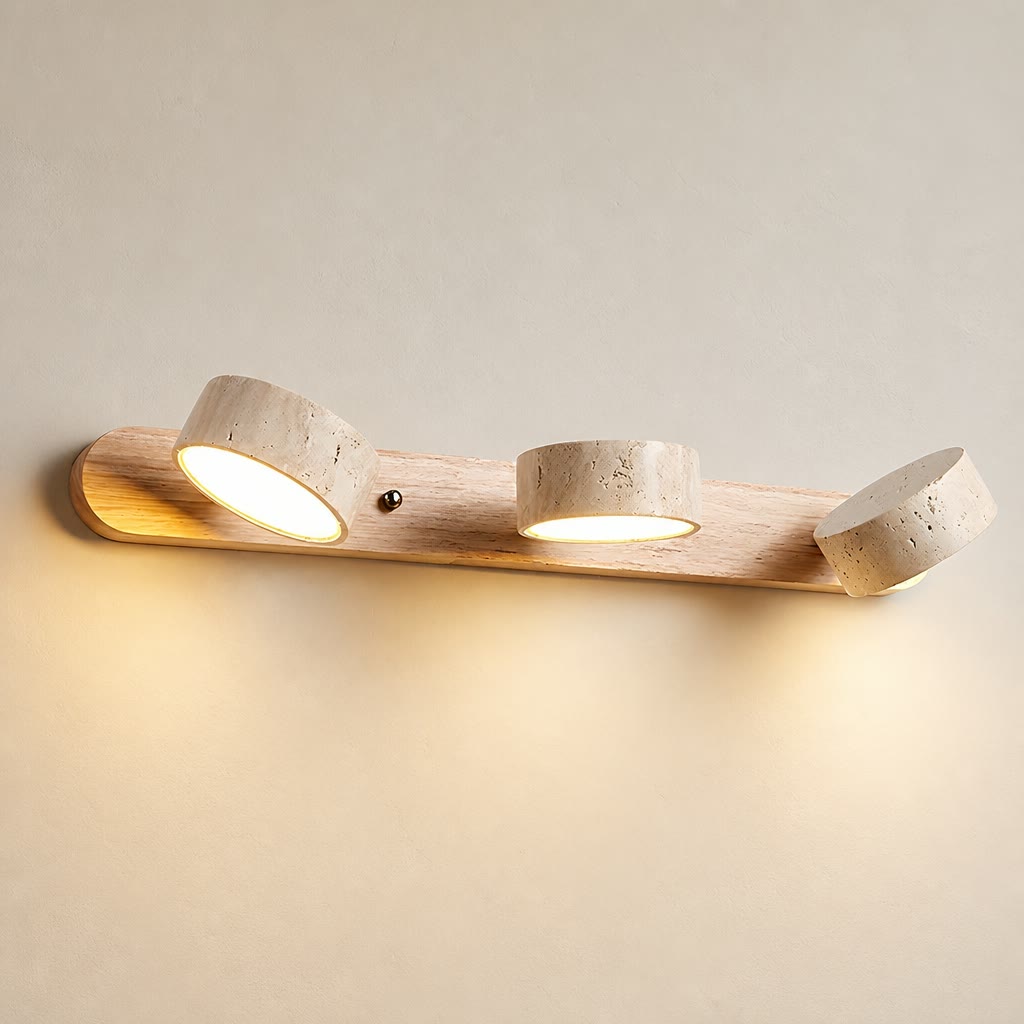 Wooden three-light wall fixture with warm glowing cylindrical spotlights.